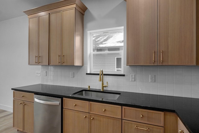 kitchen with light hardwood / wood-style floors, backsplash, dark stone counters, stainless steel dishwasher, and sink