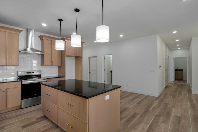 kitchen featuring stainless steel range with electric cooktop, light brown cabinets, pendant lighting, a kitchen island, and wall chimney exhaust hood