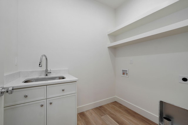 washroom featuring sink, light wood-type flooring, washer hookup, electric dryer hookup, and cabinets