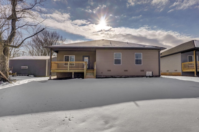 snow covered rear of property featuring covered porch