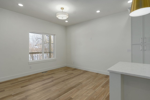 unfurnished dining area featuring light wood-type flooring