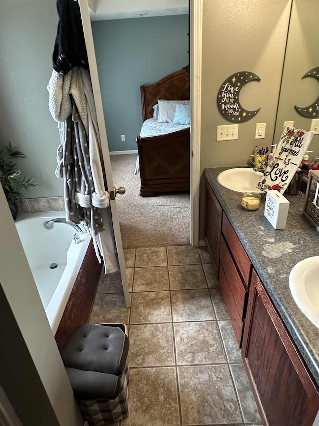 bathroom with tile patterned flooring, vanity, and a bathing tub