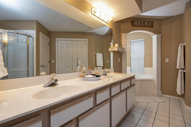 bathroom with plus walk in shower, tile patterned flooring, vanity, and decorative columns