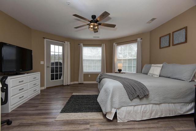 bedroom featuring ceiling fan, dark hardwood / wood-style flooring, and multiple windows