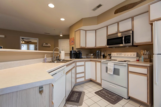 kitchen with light tile patterned floors, sink, white appliances, and white cabinetry