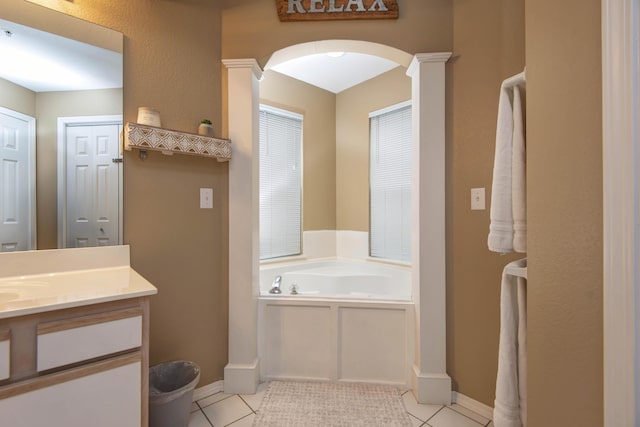 bathroom featuring ornate columns, tile patterned flooring, a tub to relax in, and vanity