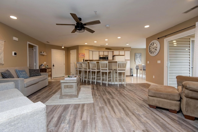 living room featuring ceiling fan and light wood-type flooring