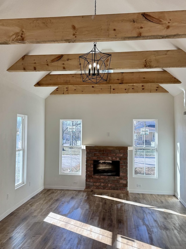 unfurnished living room featuring a brick fireplace, dark hardwood / wood-style flooring, a chandelier, and vaulted ceiling with beams