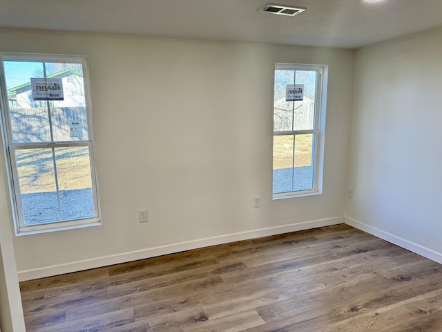 unfurnished room with plenty of natural light and hardwood / wood-style floors