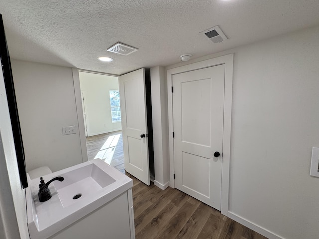 bathroom featuring a textured ceiling and hardwood / wood-style flooring