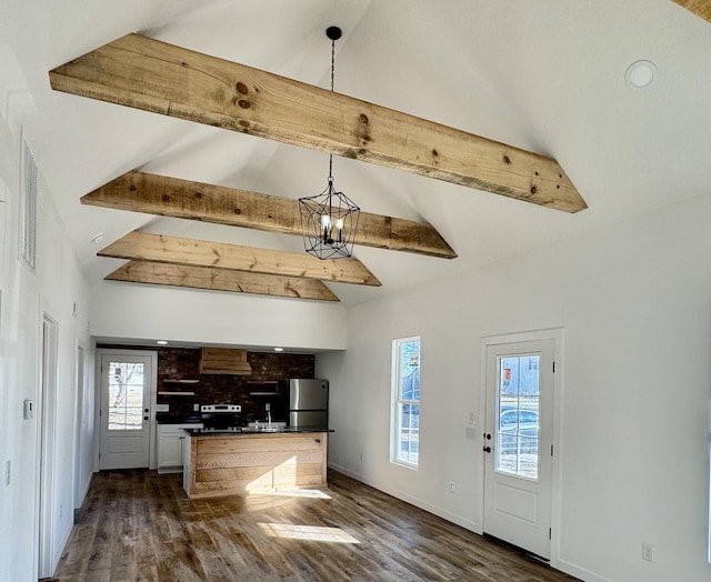 kitchen with stainless steel fridge, a notable chandelier, decorative light fixtures, dark wood-type flooring, and vaulted ceiling with beams