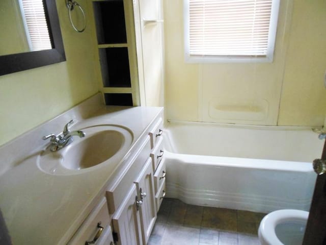 bathroom featuring toilet, vanity, and tile patterned flooring