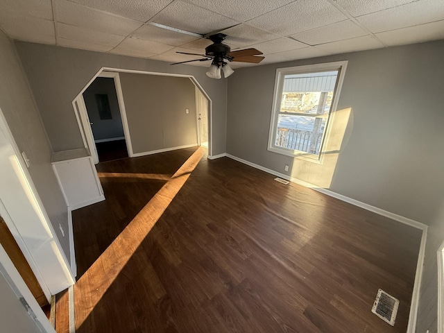 spare room featuring ceiling fan, a drop ceiling, and dark hardwood / wood-style floors