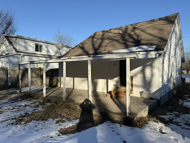 snow covered house featuring a patio