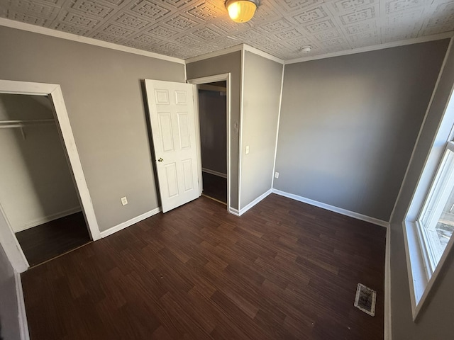 unfurnished bedroom featuring a closet and dark wood-type flooring