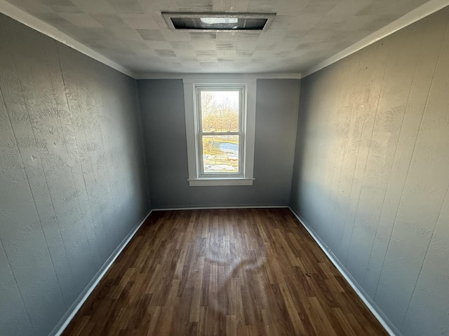 unfurnished room with crown molding, dark wood-type flooring, and wooden walls