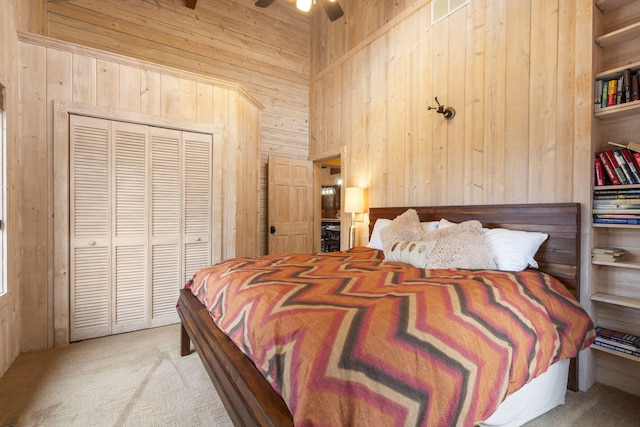 bedroom featuring light carpet, a closet, wood walls, and ceiling fan