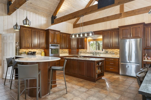 kitchen featuring a center island, decorative light fixtures, stainless steel appliances, high vaulted ceiling, and beam ceiling