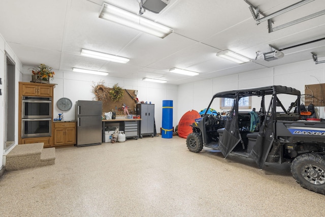 garage featuring a garage door opener and stainless steel refrigerator