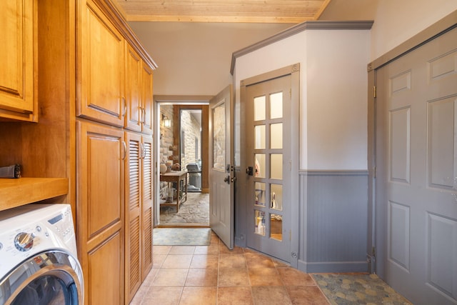 washroom featuring light tile patterned flooring, washer / dryer, and cabinets