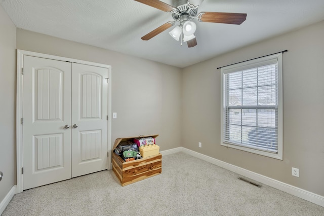 interior space with ceiling fan and light carpet