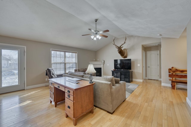 living room with a textured ceiling, ceiling fan, lofted ceiling, and light hardwood / wood-style floors