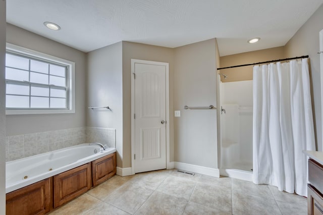 bathroom with vanity, tile patterned floors, plus walk in shower, and a textured ceiling