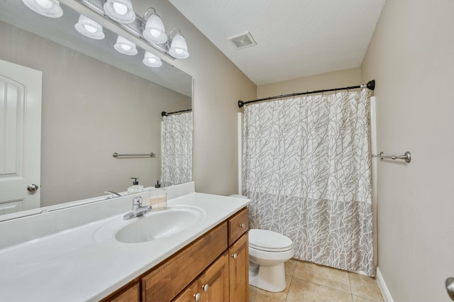 bathroom featuring toilet, vanity, tile patterned floors, and a textured ceiling