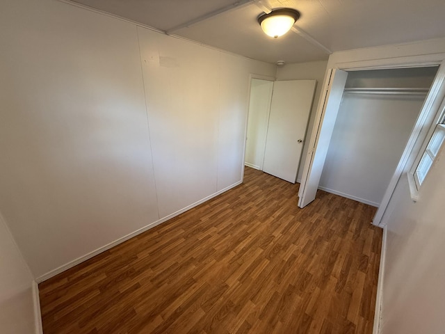 unfurnished bedroom with a closet and wood-type flooring