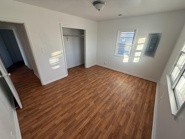 unfurnished bedroom with a closet and dark hardwood / wood-style flooring