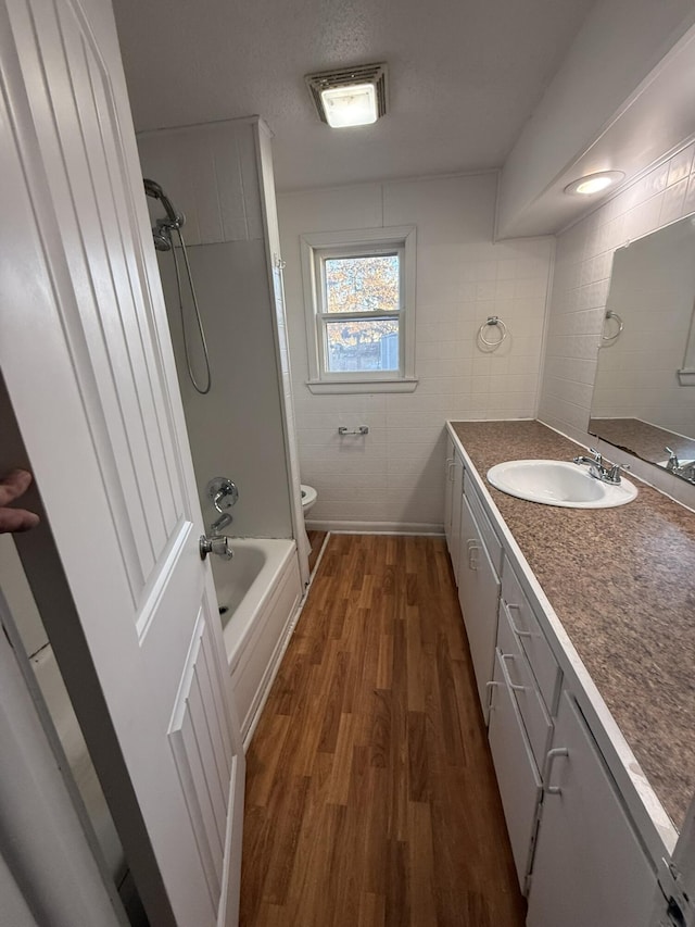 full bathroom featuring shower / washtub combination, toilet, hardwood / wood-style floors, and vanity