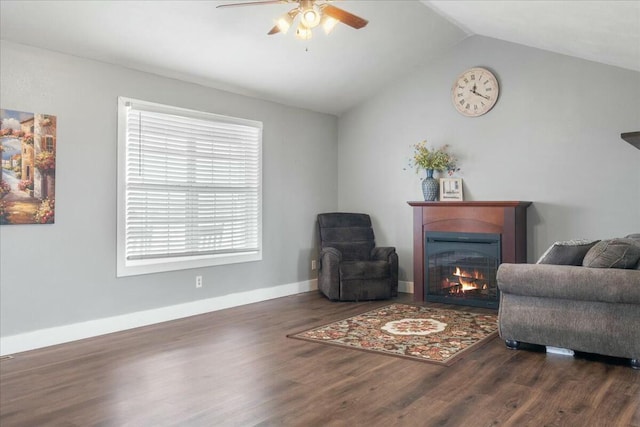 living area featuring ceiling fan, dark wood-type flooring, and lofted ceiling