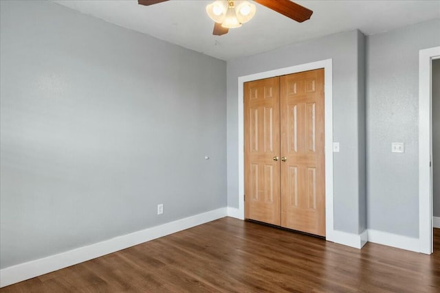 unfurnished bedroom featuring ceiling fan, dark hardwood / wood-style flooring, and a closet