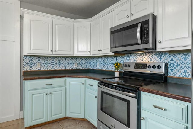 kitchen with light tile patterned flooring, stainless steel appliances, and white cabinetry