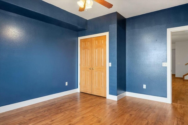 unfurnished bedroom with ceiling fan, hardwood / wood-style floors, and a closet