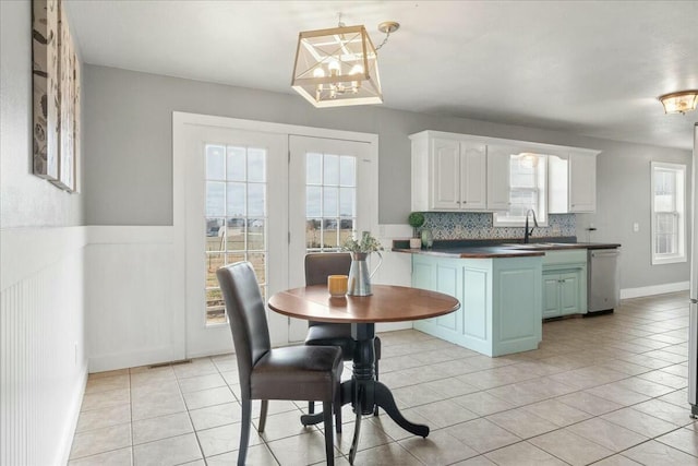 kitchen featuring white cabinets, dishwasher, sink, and plenty of natural light