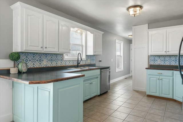 kitchen featuring sink, white cabinetry, stainless steel dishwasher, and light tile patterned flooring