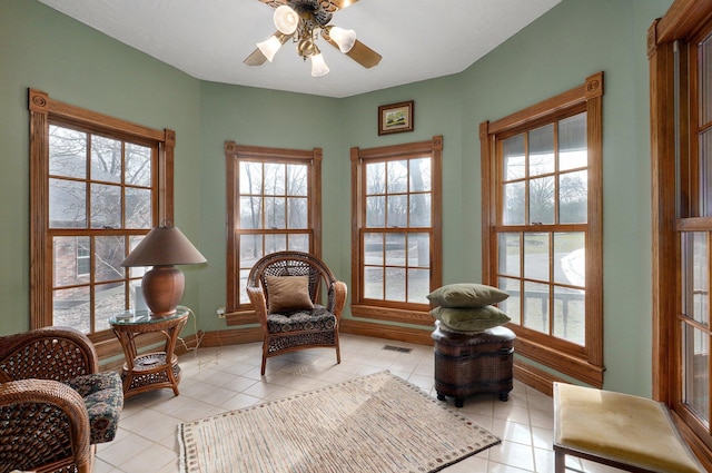 living area featuring ceiling fan, light tile patterned flooring, and a healthy amount of sunlight