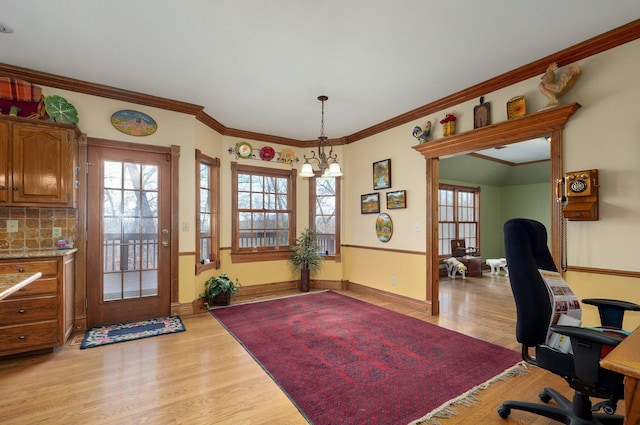 office featuring an inviting chandelier, ornamental molding, and light wood-type flooring