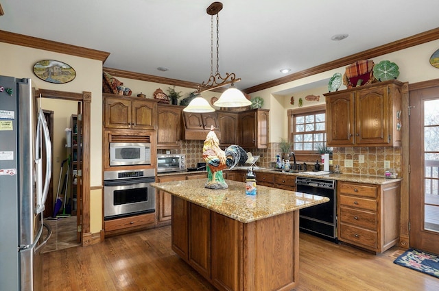 kitchen with stainless steel appliances, backsplash, hanging light fixtures, a kitchen island, and light hardwood / wood-style flooring