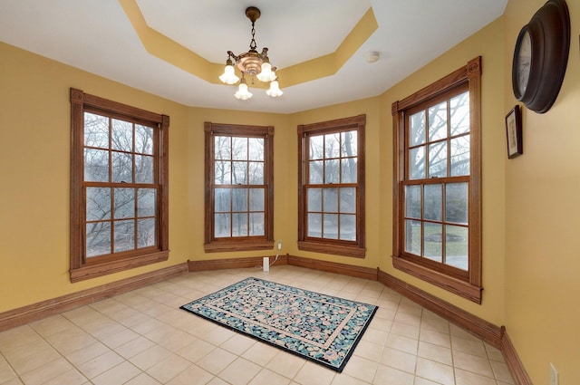 interior space featuring a wealth of natural light, a chandelier, and a raised ceiling