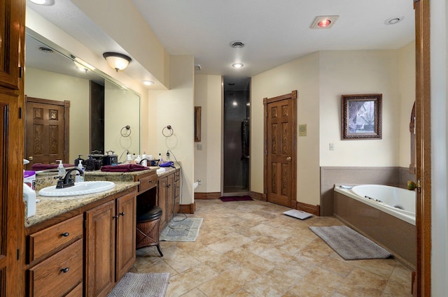 bathroom with vanity and shower with separate bathtub