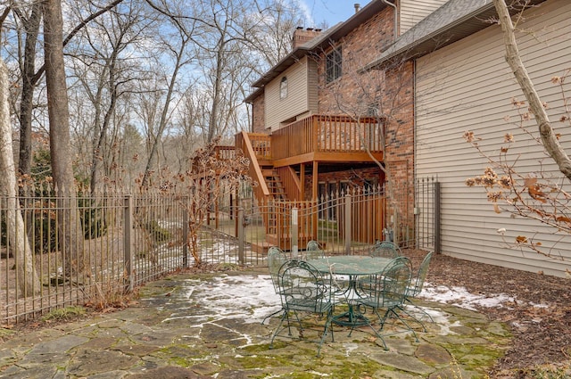 snow covered patio featuring a deck