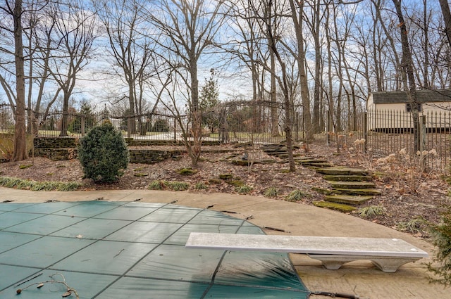 view of swimming pool featuring a diving board