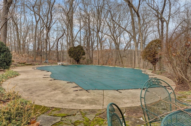 view of pool featuring a diving board and a patio