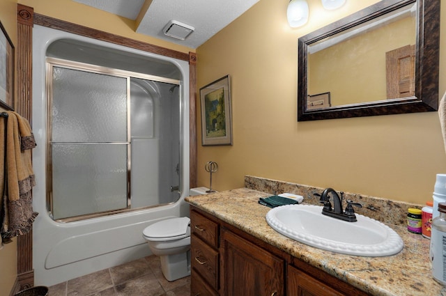 full bathroom featuring toilet, a textured ceiling, vanity, and shower / bath combination with glass door