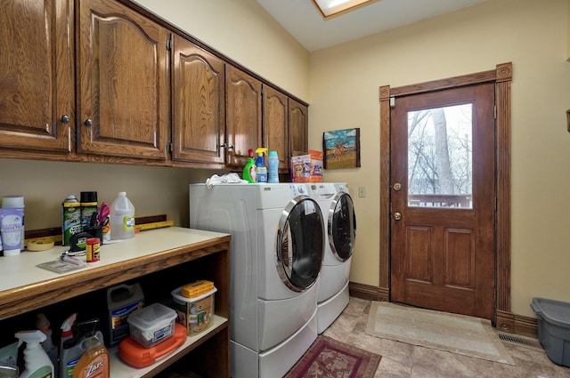 washroom with cabinets and washing machine and clothes dryer