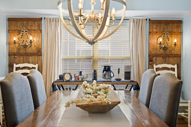 dining area with a notable chandelier and wooden walls