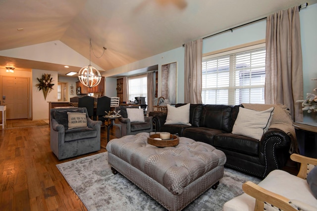 living room featuring lofted ceiling, a chandelier, and hardwood / wood-style flooring