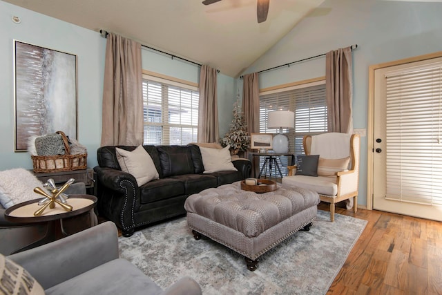 living room featuring vaulted ceiling, ceiling fan, a wealth of natural light, and light wood-type flooring